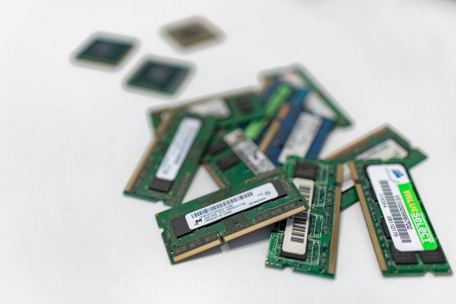 Barrettes de mémoire et puces posées en vrac sur une surface blanche